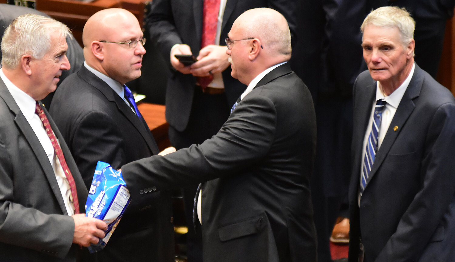 STATE REP. BRUCE SASSMANN passes out Life Savers candy to fellow representatives Jan. 3 as the House prepared to convene for the first time in the final session of the 102nd General Assembly.